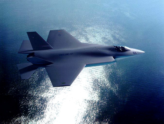 a topside view of an F-35 flying over water